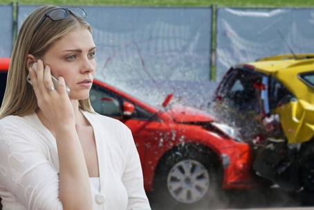 woman on cell phone with crashed cars in background