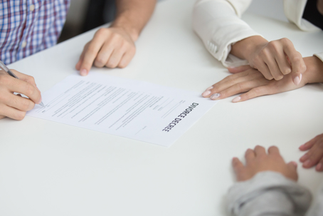Husband signing uncontested divorce decree paper giving permission to break up, unhappy couple get divorced in lawyers office, marriage dissolution concept, close up view of hand putting signature