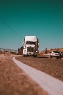 White big rig approaches the camera on the highway